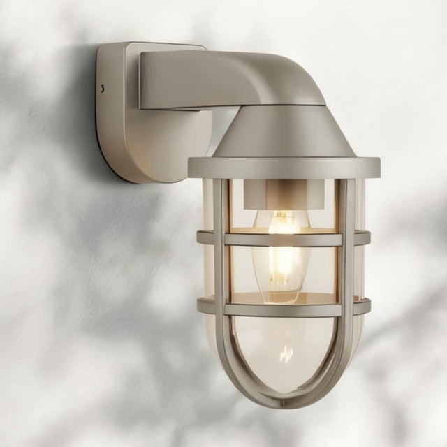 "A weather-resistant wall lamp with a rugged industrial design, featuring a gray finish, a robust cage structure, and a clear PC diffuser, suitable for outdoor and indoor spaces."