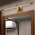 "A gold wall lamp with a Greek key pattern mounted above a framed bathroom mirror, reflecting an air conditioning unit."