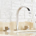 Modern chrome three-hole bathroom faucet with curved spout on cream marble counter and white subway tile backsplash.