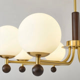 "Close-up of Ralie chandelier with iron, wood, and frosted glass globes showing detailed construction."