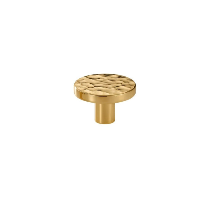"A hammered brass round knob with a textured, artisanal look."