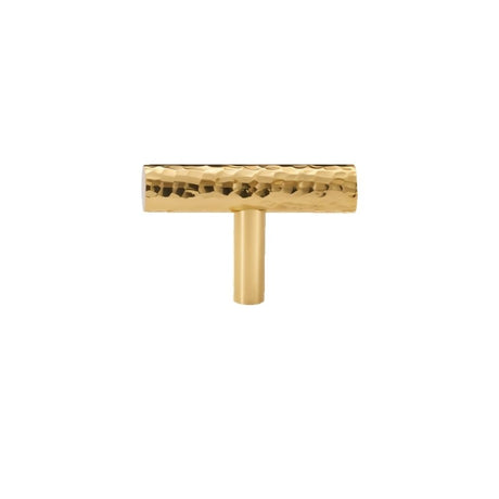 "A hammered brass t-shaped knob with a textured, artisanal design, suitable for cabinetry and drawers."