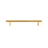 "A hammered brass pull bar with a textured, artisanal design, suitable for cabinetry and doors."