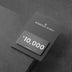 Black gift card with white "$10,000" text displayed on dark textured background.