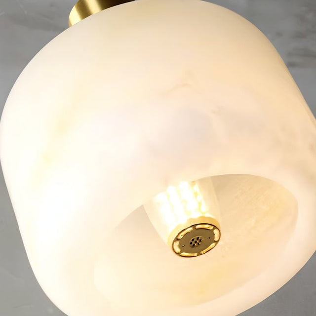 "Close-up of a rounded alabaster pendant light shade, showing its natural veining and soft, diffused light."