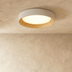 Round ceiling light fixture with white and natural wood finish on neutral background, viewed from below.