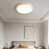 "A minimalist, natural travertine ceiling light illuminates a modern bedroom with artwork and soft, uniform light."
