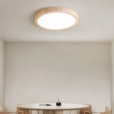 "A minimalist, natural travertine ceiling light illuminates a modern dining room with soft, uniform light."