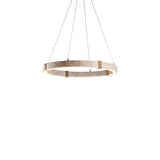 "Minimalist circular chandelier featuring travertine, iron, and acrylic, suspended by thin cables in a modern setting."