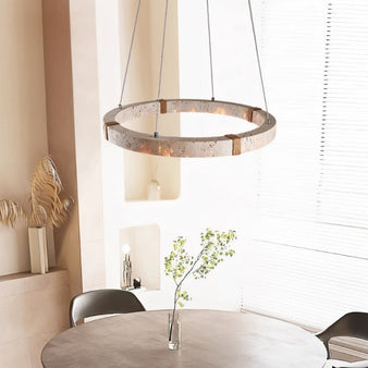 "Circular chandelier made of travertine, iron, and acrylic hanging in a modern home, complementing the minimalist and naturalistic design."