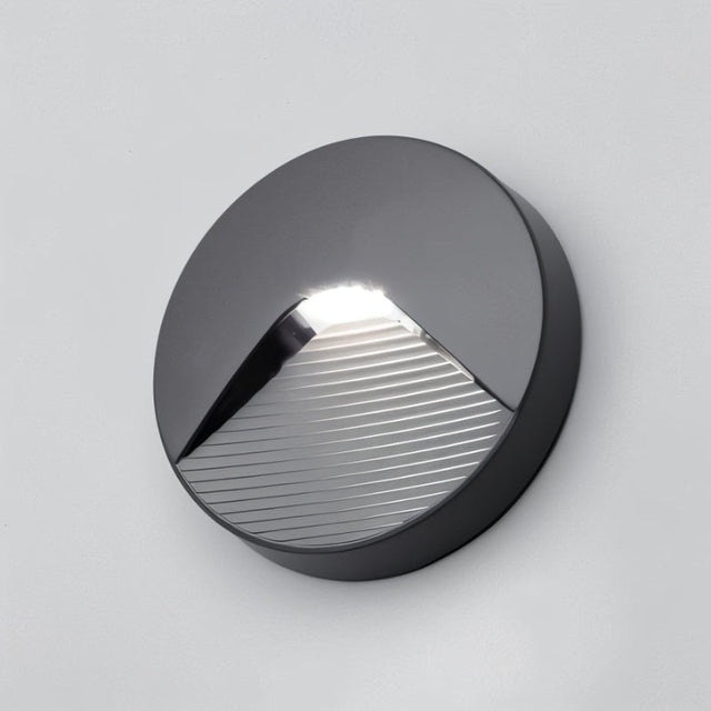 "A sleek, round outdoor wall light with a clear acrylic diffuser, providing a soft, focused downward glow for pathways and enhancing visibility in any environment."