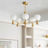 "A 6-light gold sputnik chandelier with frosted glass globes, hanging in a room with built-in shelves."