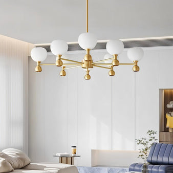 "An 8-light gold sputnik chandelier with frosted glass globes, hanging in a modern living room with a couch and decor."