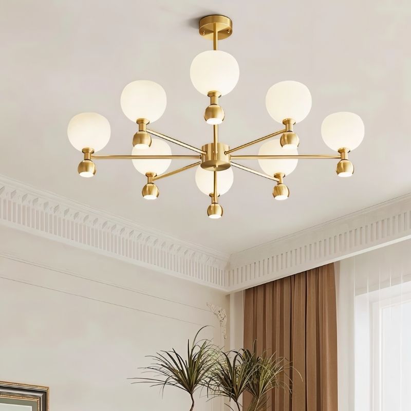 "An 8-light gold sputnik chandelier with frosted glass globes, hanging in a room with a decorative ceiling and plants."