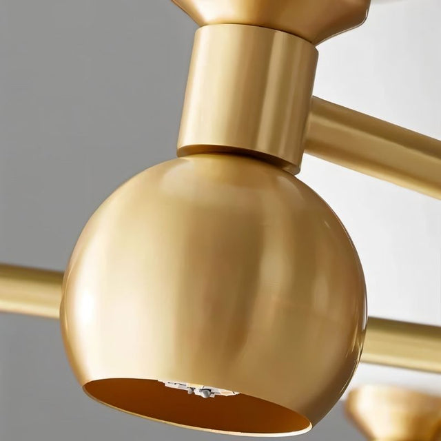 "A close-up view of a gold sputnik chandelier with a gold globe and metal frame."