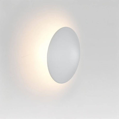 Close-up of the Rochi Wall Lamp in white aluminum, showcasing its round, minimalistic design and soft ambient lighting.