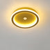 Modern oval ceiling light with brass finish and white LED rings against white ceiling.
