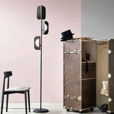 "A black floor lamp in a bedroom setting with a chair and wardrobe."
