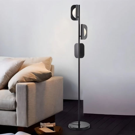 "A black floor lamp in a living room with a modern sofa."