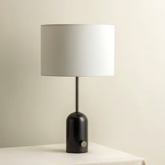 "Table lamp with black marble base, metal stem, drum-shaped lampshade, clean and modern lighting fixture"