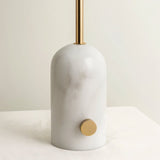 "Close-up of white marble base with brass accents, smooth and sturdy construction, modern and minimalist design"