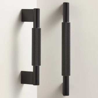 "Pair of black knurled brass pull bars with clean edges, blending industrial design and functionality for modern spaces."