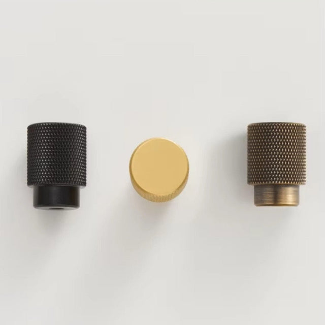 "Knurled brass knobs in three finishes: black, gold, and antique, suitable for modern cabinetry and drawers."