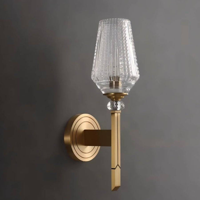 "Close-up of a modern wall lamp with a copper base, luxurious gold finish, and intricately textured glass shade."