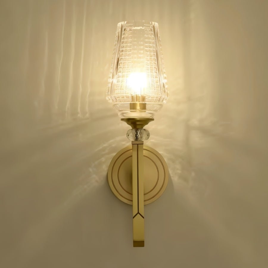 "Modern gold wall lamp with a textured glass shade, emitting a soft and elegant glow."