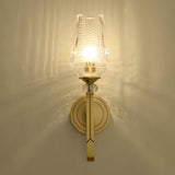 "Modern gold wall lamp with a textured glass shade, emitting a soft and elegant glow."