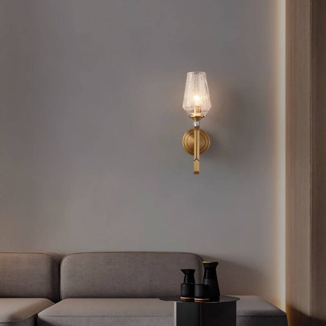 "Modern wall lamp with copper base, gold finish, and textured glass shade illuminating a contemporary living room."
