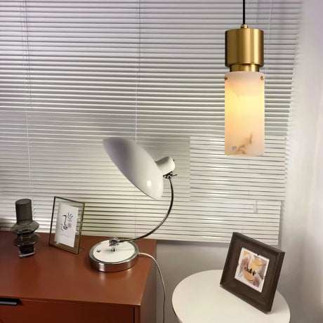 "Modern pendant light with an alabaster shade and copper accents, illuminating a contemporary home office."