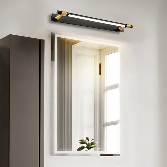 "A modern black and gold wall lamp with an adjustable cylindrical light bar above a rectangular bathroom mirror."
