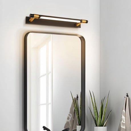 "A modern black and gold wall lamp with a sleek, adjustable cylindrical light bar mounted above a rounded rectangular bathroom mirror."