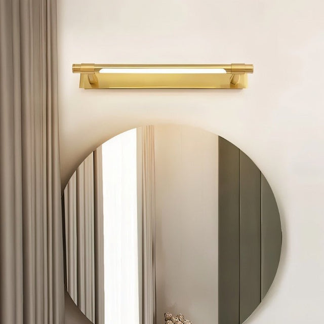 "A modern gold wall lamp with a sleek, adjustable cylindrical light bar mounted above a round mirror in a contemporary bathroom."