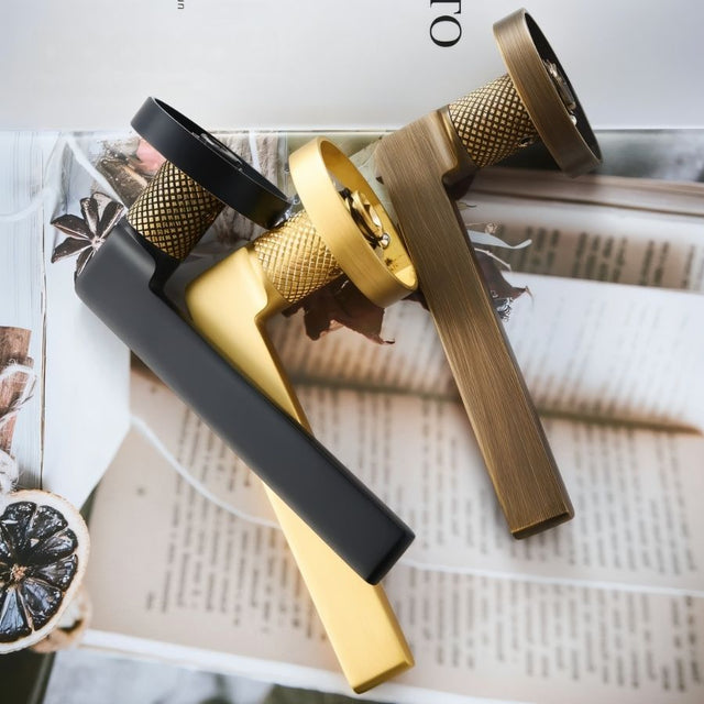 Sabaat Handle and Lock set in gold, bronze, and black with knurled grips, displayed on a magazine for aesthetic appeal.