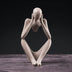 # Alt Text

Abstract stone figurine in seated pose with head bowed, displayed on wooden surface against black background.