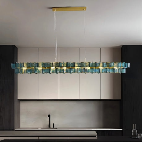 "Iron Salane chandelier with layered blue glass elements hanging above a modern kitchen with grey cabinets."