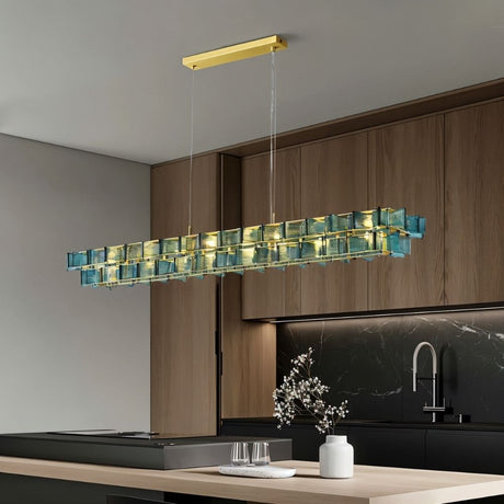 "Iron Salane chandelier with layered blue glass elements hanging above a kitchen island with wooden cabinets."