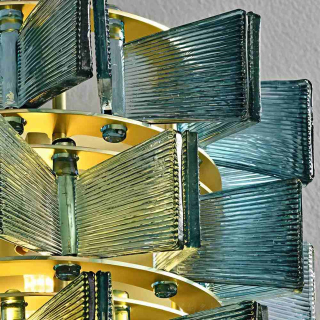 "Close-up of an iron Salane wall lamp showing the intricate frame and layered blue glass panels."