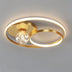 Modern brass ceiling light with integrated LED rings and crystal sphere accent on neutral background.