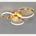 Gold modern ceiling light with three illuminated rings and a crystal globe center on gray background.