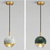 Pendant light with white marble and brass finishes, suspended against a neutral gray background.