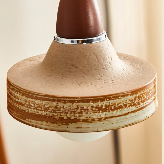 "Close-up of a handcrafted pendant light with a textured ceramic shade and wooden top, showcasing its rustic and modern design."