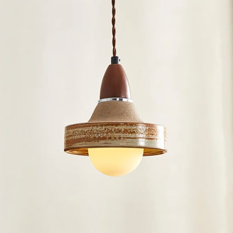 "Handcrafted ceramic and wood pendant light with a textured shade illuminated, creating a warm and inviting ambiance."