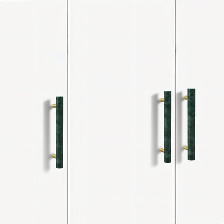 "Modern green marble and brass pull bars on a minimalist white cabinet, showcasing elegant hardware."
