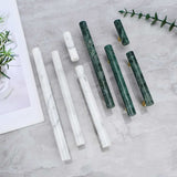 "Assortment of marble and brass knobs and pull bars on a marble countertop, showcasing modern hardware."