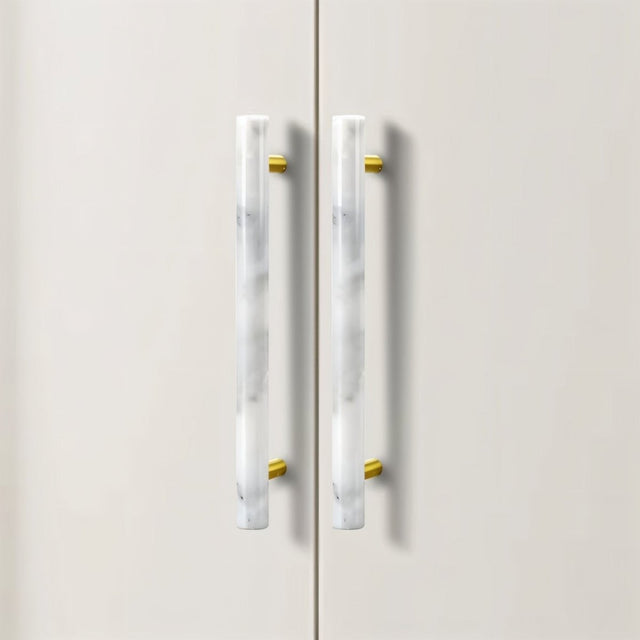"Close-up of a marble and brass pull bar on a white cabinet, showcasing its elegant design."