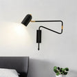 "Black and gold adjustable arm bedside reading lamp mounted above a bed."