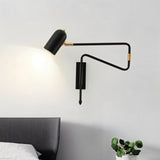 "Black and gold adjustable arm bedside reading lamp mounted above a bed."